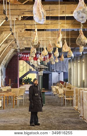 Ghent, Belgium - December 19, 2010. Tourist Looks At Ganda Ham Hanging In The Great Butchers Hall (g