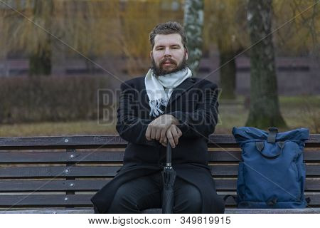 Middle Adult Bearded Man Have Rest With Closed Eyed And Smiling Face On Bench In Autumn Park Hold Um