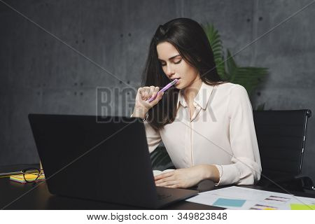 Millennial Woman Executive Sitting At Desk In Office, Using Portable Digital Devices For Work. Girl 