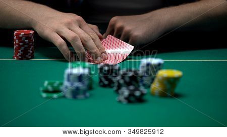 Man Checking Cards And Raising, Bluffing During Poker Tournament, Chance To Win