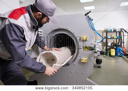 Men Workers Get Carpet From An Automatic Washing Machine And Put In In Dryer In The Laundry Service