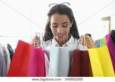 Girl Takes Pleasure From Shopping At Boutique. Girl Holds In Hands Lot Multi-colored Bright Packages