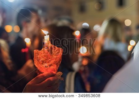 Closeup Of People Holding Candle At Night During Church Service