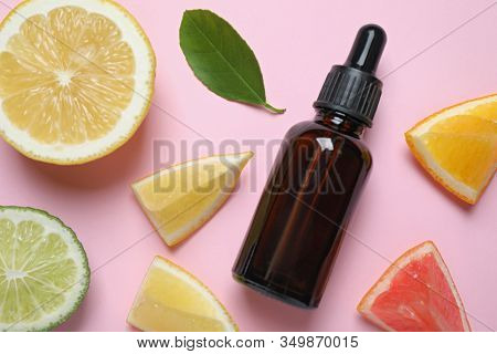 Flat Lay Composition With Bottle Of Citrus Essential Oil On Pink Background