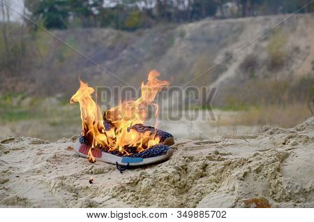 Burning Sports Sneakers Or Gym Shoes On Fire Stand On Sandy Beach Coast. Athlete Burned Out. Physica