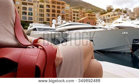 Woman Sitting Near Pier, Opened Purse As Concept Of Pickpocketing In Resorts