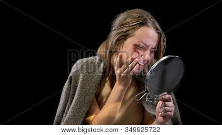 Depressed Woman With Wounded Face Looking In Mirror And Crying Black Background