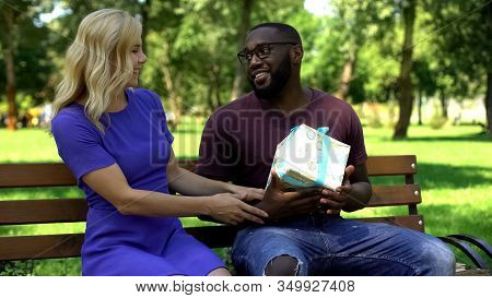 Afro-american Man Getting Surprise Present From Female Friend In Park, B-day