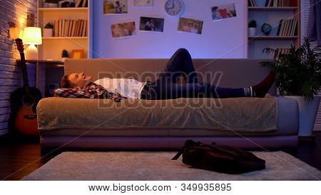 Satisfied Smiling Teenager Student Coming Home, Lying Down On Sofa, First Job