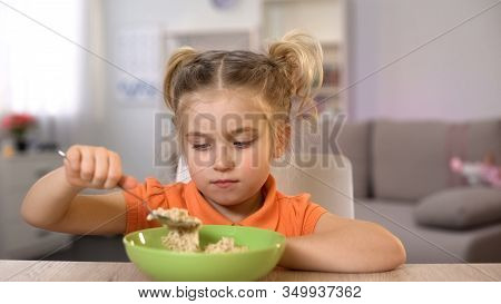 Unhappy Girl Looking At Oatmeal, Healthy But Tasteless Nutrition, Dieting