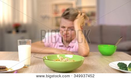 Unhappy Boy Looking Oatmeal With Disgust, Unappetizing Food, Healthy Breakfast