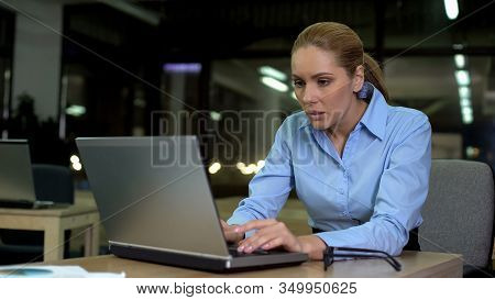 Nervous Female Working On Laptop At Night, Stressful Job Causing Health Problems