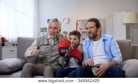Excited Multiage Family Members Cheering For Favorite Boxer Watching Game On Tv