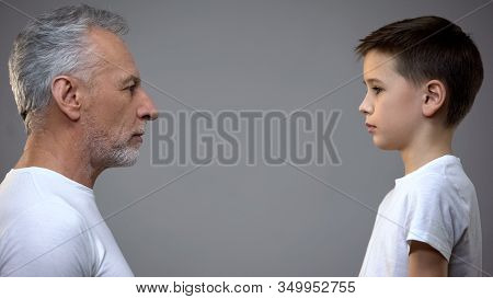 Senior Male And Teen Boy Maintaining Eye Contact, Generation Gap, Aging