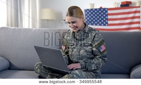 Cheerful American Soldier Woman Making Videocall On Laptop Pc At Home, Military