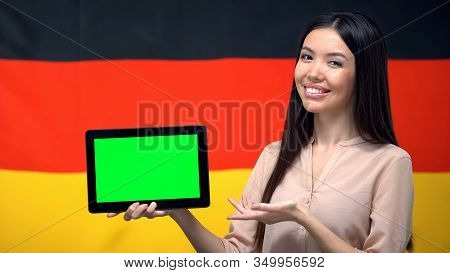 Girl Holding Tablet With Green Screen, Germany Flag On Background, Migration