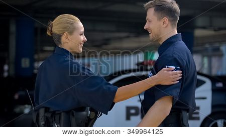 Police Mates Greeting Each Other Standing Near Patrol Car, Ready To Carry Duties