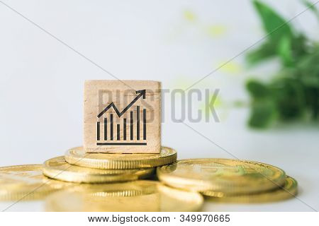 Graph Rising Up Growht Exponencial Sign On Wooden Cube With Objects Such As Gold Coin, Calculator An