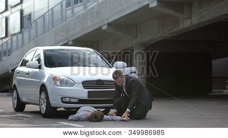 Auto Driver Checking Victim Pulse At Car Accident Scene, Traffic Rules Violation