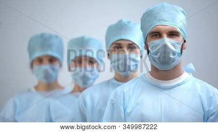 Professional Surgeon Team In Mask And Uniform Looking At Camera, Hospital Work