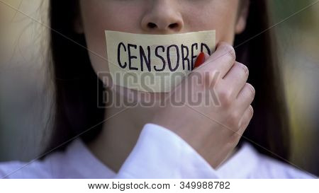 Woman Taking Off Tape With Censored Word Over Mouth, Democracy Concept, Freedom