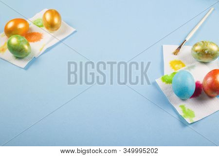 Only Painted Eggs Of Rakh Flowers With A Gold Dusting Dry On Napkins Next To A Brush On A Blue Backg
