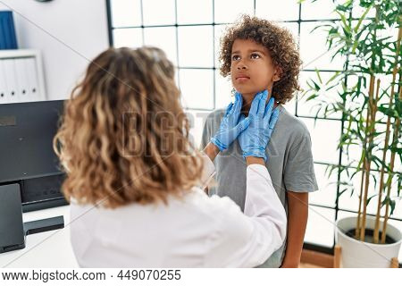 Mother and son examining thoat at clinic