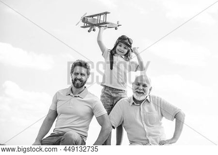 Three Generations Of Men Together, Portrait Of Smiling Son, Father And Grandfather With A Toy Airpla