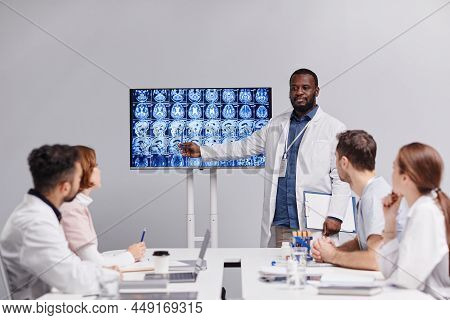 Contemporary Medical Expert Or Radiologist Pointing At Mri Scan With X-ray Images Of Human Brain Dur