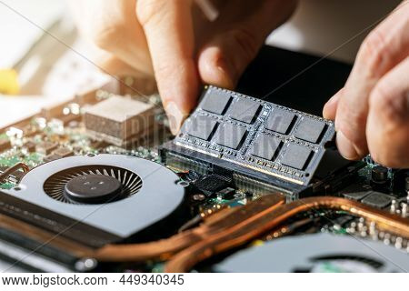 Technician Installing Ram Memory Module In Laptop Motherboard. Computer Upgrade