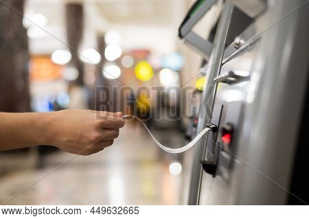 A Woman Takes A Train Ticket From A Self-service Ticket Office.