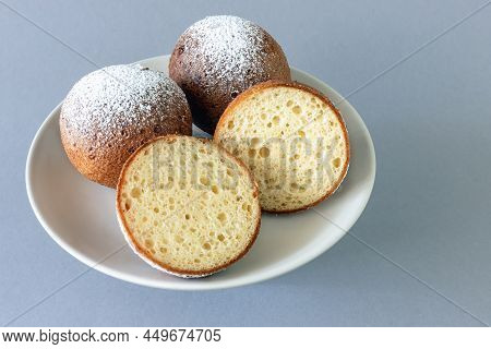 Top View Of A Plate Of Lithuanian Large Donuts With One Cut In Two On A Gray Background