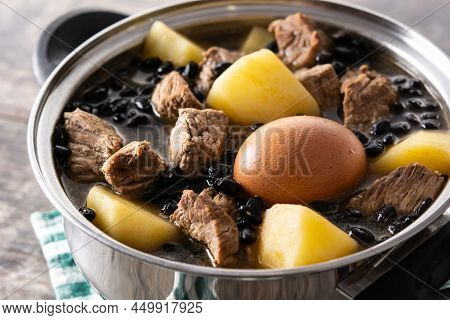 Traditional Jewish Cholent In Casserole On Wooden Table. Close Up