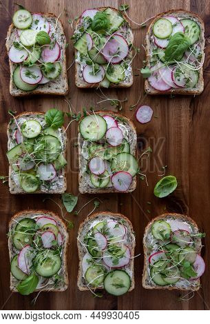 Cucumber And Radish Open Faced Sandwiches On A Wooden Board With Copy Space.