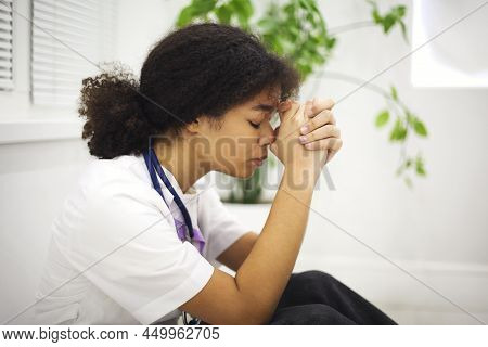 Sad Depressed Young African American Nurse Sitting On Floor With Frustrated Face Expression, Feeling