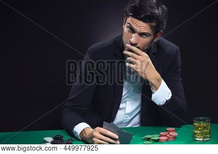 Gaming Concepts. Depressed Sad Caucasian Brunet Pocker Player At Pocker Table With Chips And Cards W