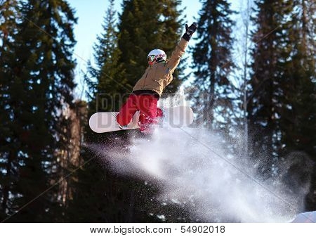 Snowboarder jumping through air with deep blue sky in background