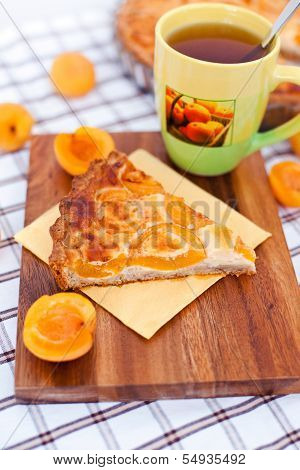 Piece Of Apricot Tart On The Wooden Board With Cup Of Tea
