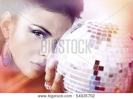 Beautiful young woman holding disco ball