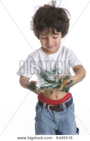 Kleine jongen kijkt zijn Shirt vol groene verf