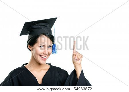 Graduating student in black academic gown and cap making the attention gesture, isolated on white background