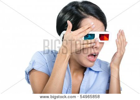 Scared girl in 3D glasses watches film through hands, isolated on white