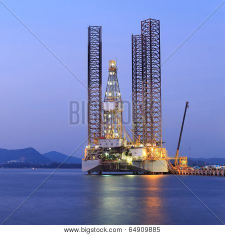 Jack Up Oil Drilling Rig In The Shipyard For Maintenance At Sunset Time