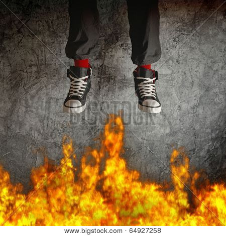 Young Man In Sneakers Is Jumping Over Fire