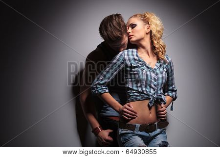 passionate casual young couple standing embraced in studio