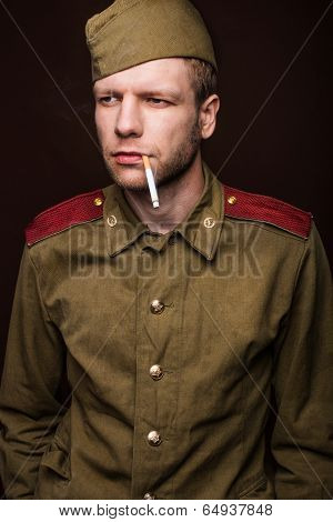 Second world war russian soldier smoking cigarette and looks at something