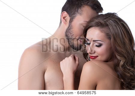 Sexy naked girl shyly hiding in arms of lover