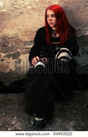 Beautiful serious girl by the wall