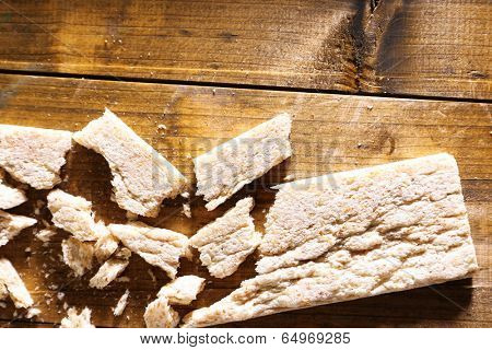 Crushed dietic rye bread on wooden background