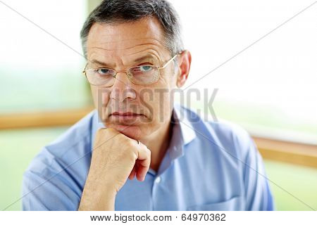 Senior man in glasses looking at camera